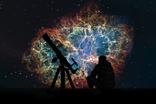 Im Fernglas sieht man viele funkelnde Lichtpünktchen in den Plejaden.  Shutterstock