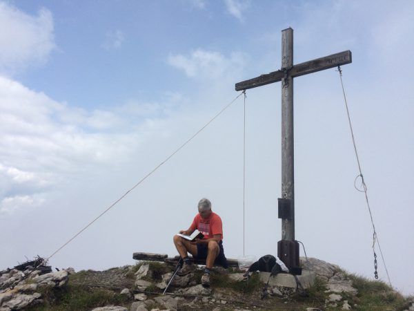Rasten am Gipfelkreuz. Der Aufstieg lohnt sich.