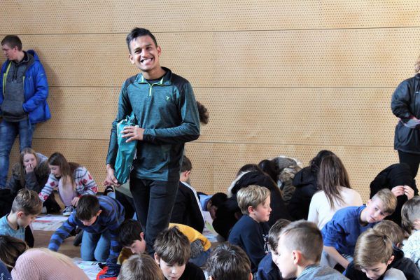 Imer Gutiérrez inmitten malender Schüler bei der Auftaktveranstaltung an der Öko-Mittelschule Mäder. DKA