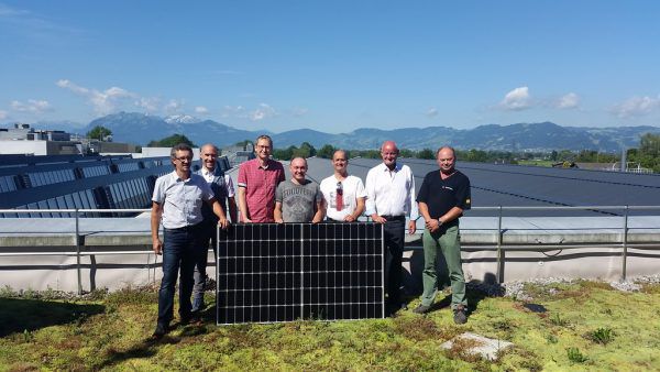 Werksleiter Markus Kronenwett (Zweiter von rechts) und das Projektteam über den Dächern der Fertigungshallen.  Zumtobel