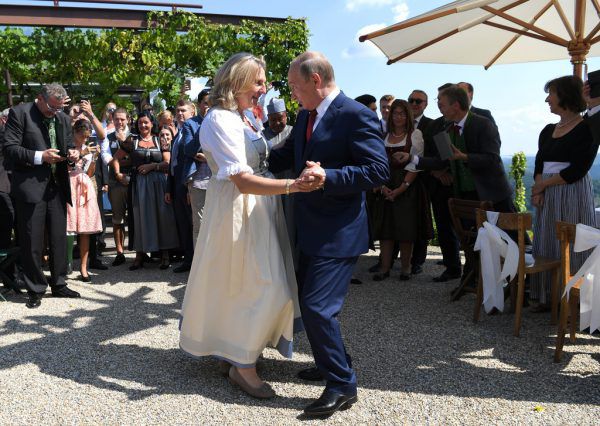 Bei der Hochzeit von Karin Kneissl und Wolfgang Meilinger (oben) tanzte Wladimir Putin mit der Braut (links). Dann ging es nach Berlin zu Angela Merkel (unten). Reuters (2), AFP