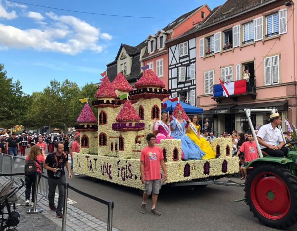 Bunte Wagen fahren beim Blumencorso durch die Straßen. Stadt Dornbirn