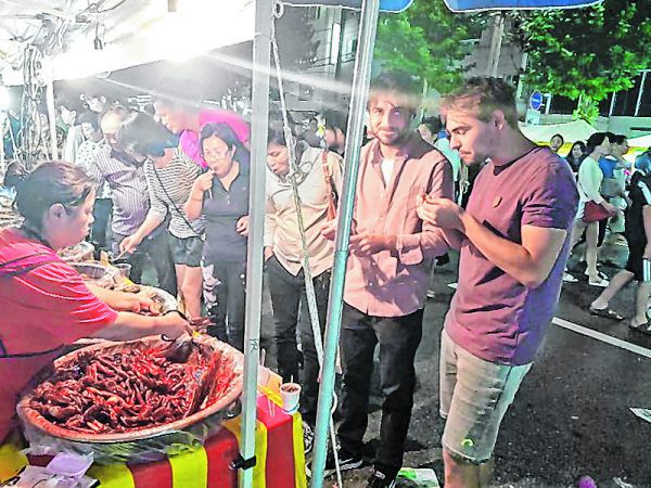 Ralf Bilgeri (rechts) und Lucas Loacker probieren sich bei einem Marktstand durch verschiedenste Köstlichkeiten.