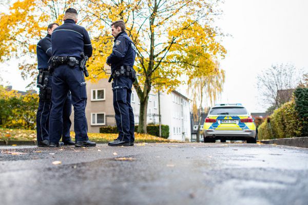 Polizisten vor dem Mehrfamilienhaus, in dem sich die Tat ereignete. Guido Kirchner