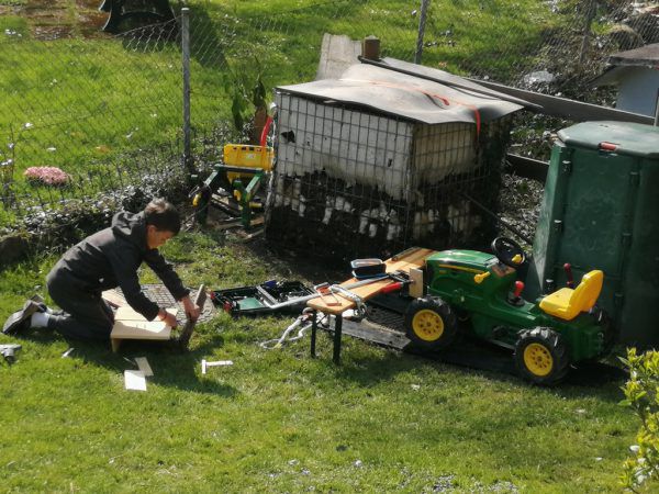 Martin baut sich eine Ladefläche für seinen Tret-Traktor.