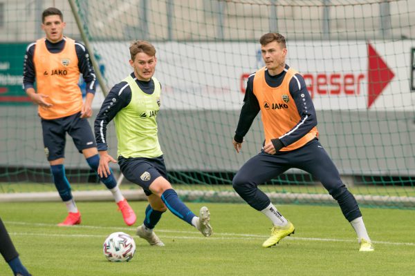 Johannes Tartarotti (in Gelb) kommt gegen Philipp Schmiedl (r.) zu spät.  stiplovsek