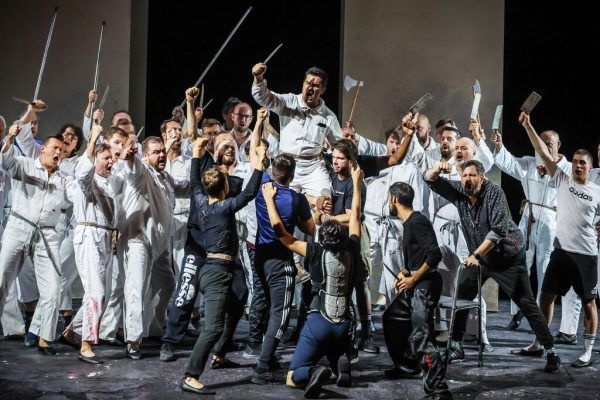 Massenszene mit Chor und Stuntmen und Tenor Saimir Pirgu (in der Mitte oben mit Messer).