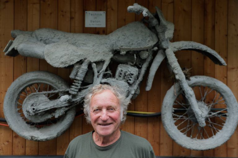 Peter Hinterreiter vor einer in Beton gegossenen Motocross, die an seiner Garage hängt. Und mit seiner KTM (r.), mit der er immer noch unterwegs ist. Klaus Hartinger