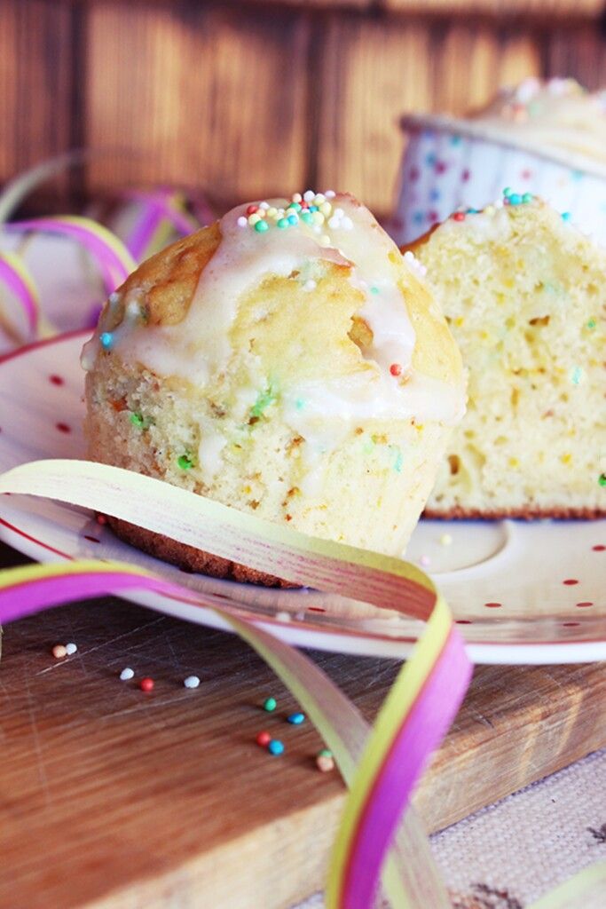 Bunte Orangenmuffins mit glitzernder Faschingsglasur.