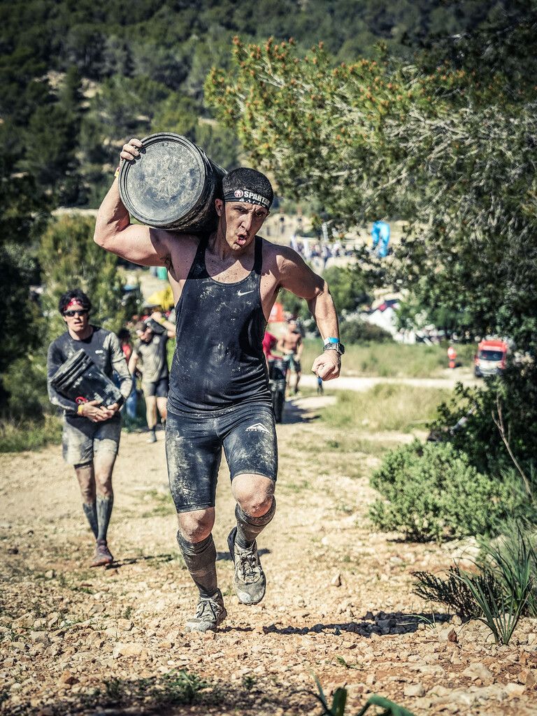 Oben: David Guerrero beim Schleppen eines schweren Eimers.Spartan Race