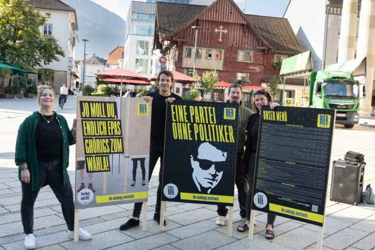 Nadine Lins (l.) und Michaela Haller (r.) enthüllen mit Dominik Wlazny (in schwarz in der Mitte) die Plakate der Bierpartei.