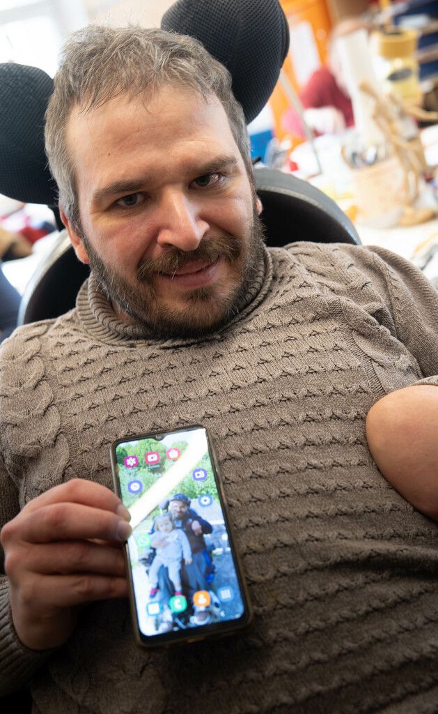 Das Foto auf dem Handy zeigt ihn mit seiner kleinen Nichte. ⇒