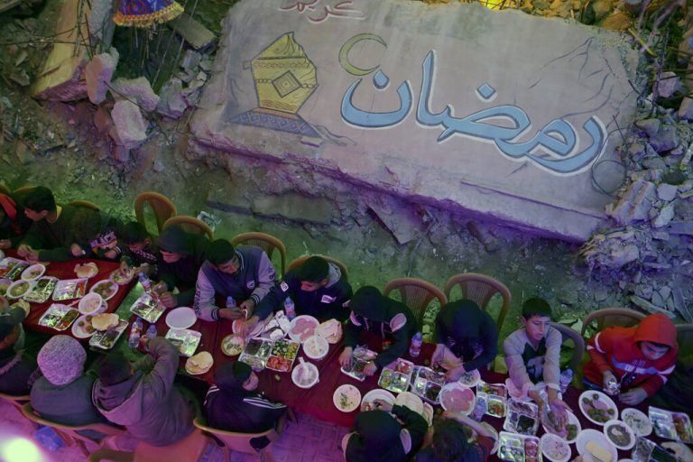 Inmitten der Trümmer ihrer zerstörten Häuser sitzen die Menschen zum Frühstück vor dem Morgengrauen (Suhur) zusammen.⇒AP