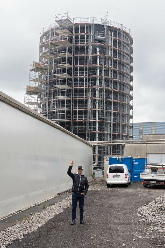 Tobias Ilg vor dem neuen Wärmespeicher in Dornbirn. Das fast 30 Meter hohe Bauwerk im Hintergrund fasst sechs Millionen Liter Wasser. ⇒⇒Hartinger (4)
