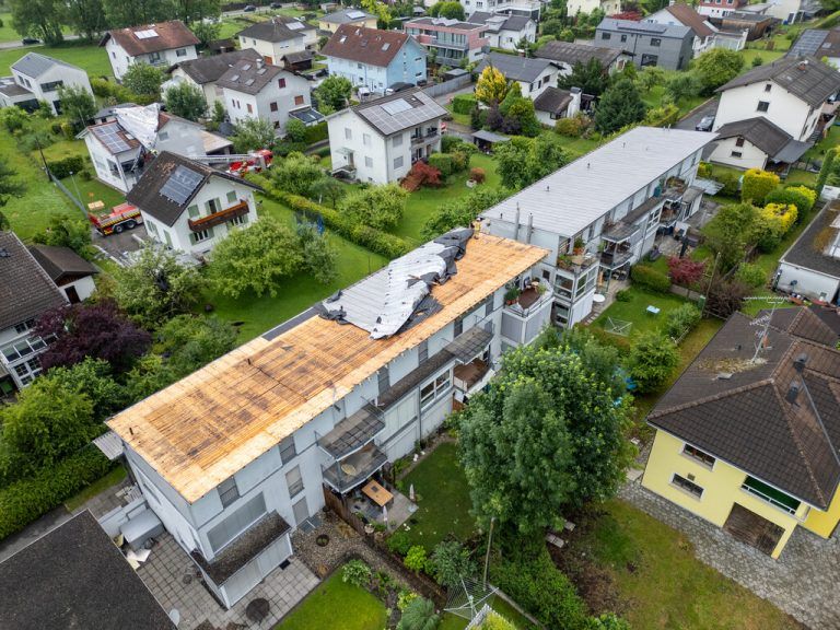 Das Dach dieser Wohnanlage am Rosshimmel 17 in Dornbirn wurde meterweit durch die Luft geschleudert un blieb auf einem benachbarten Einfamilienhaus liegen. ⇒Hartinger