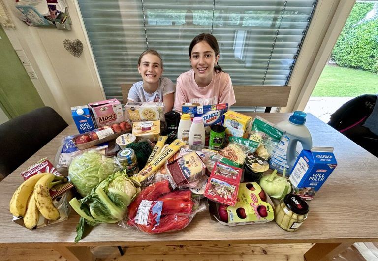 Der gesamte Wocheneinkauf liegt ausgebreitet auf dem Tisch – Emily und Aylin zeigen, was für eine vierköpfige Familie derzeit notwendig ist. ⇒huber