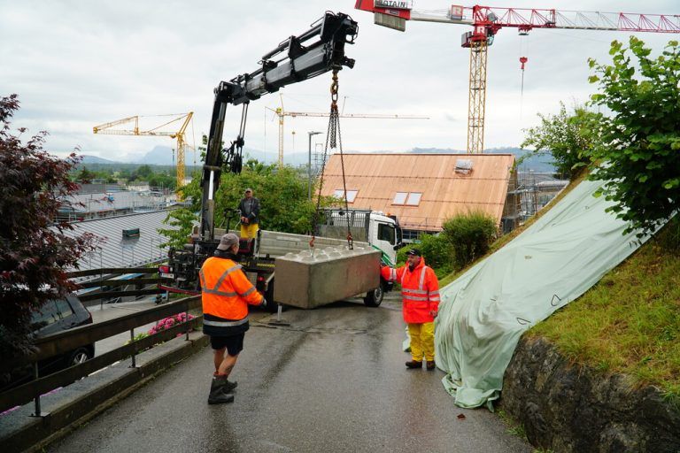 Mitarbeiter des Bauhofs Wolfurt sichern Hang und Straße mit Betonelementen.⇒NEUE (12), vol.at