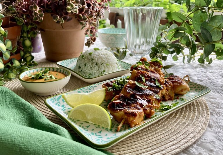 Goldbraune Saté-Spieße mit cremiger Erdnusssauce serviert auf duftendem Kokosreis mit frischem Koriander und Limette.⇒Ulrike Hagen