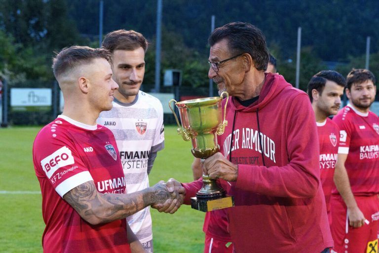 NEUE-Unterhaus-Experte Günther Böhler überreicht Bizau-Kapitän Simon Thurner den Meisterpokal der Hansesun Super Liga.⇒Dietmar Stiplvosek