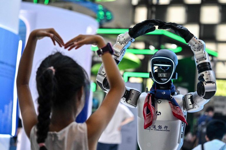 Ein Mädchen spielt mit einem Roboter während der World Artificial Intelligence Conference (WAIC) im Shanghai World Expo and Convention Center in Shanghai.⇒AFP