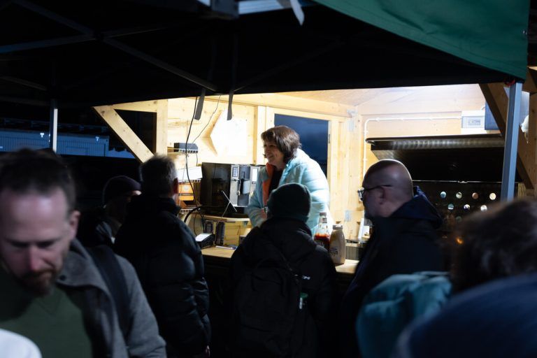Der Abend in Bildern: Links die Warteschlange vor dem Imbisstand, rechts klatschen die Spieler des HC Prättigau-Herrschaft mit Betreuerin Flurina Camichel ab. Rechts im grasgrünen Anzug: Klubpräsident Stephan Weber.