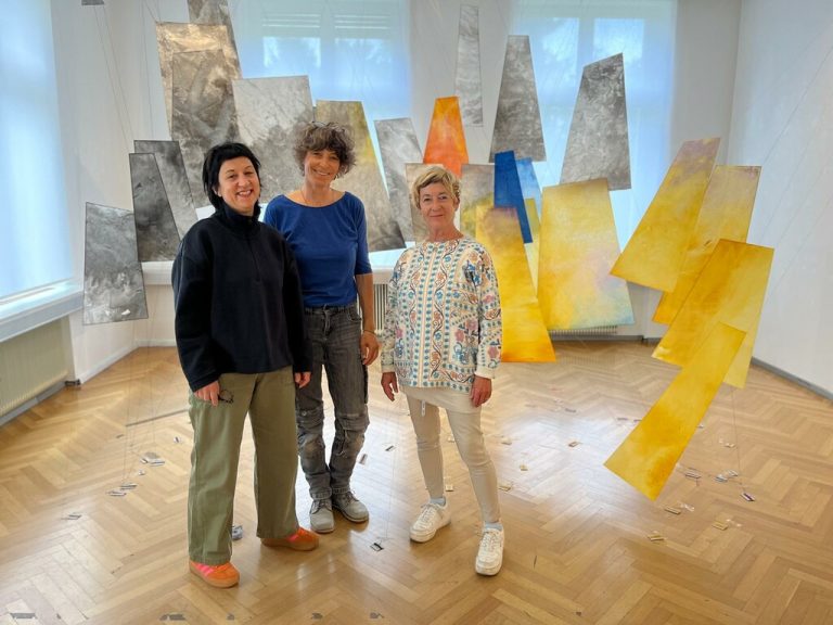 Renate Wittwer (l.), Anna Rubin und Birgit Konzett vor der aus bespannten Papiersegeln bestehenden Berglandschaft Rubins.⇒neue